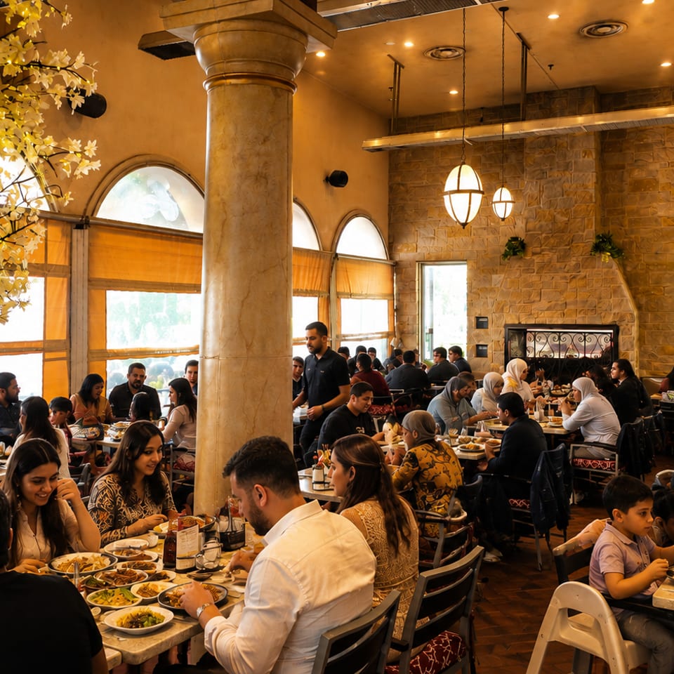 Diners enjoying meals in a bustling restaurant with a decorative lighted tree and stone walls.